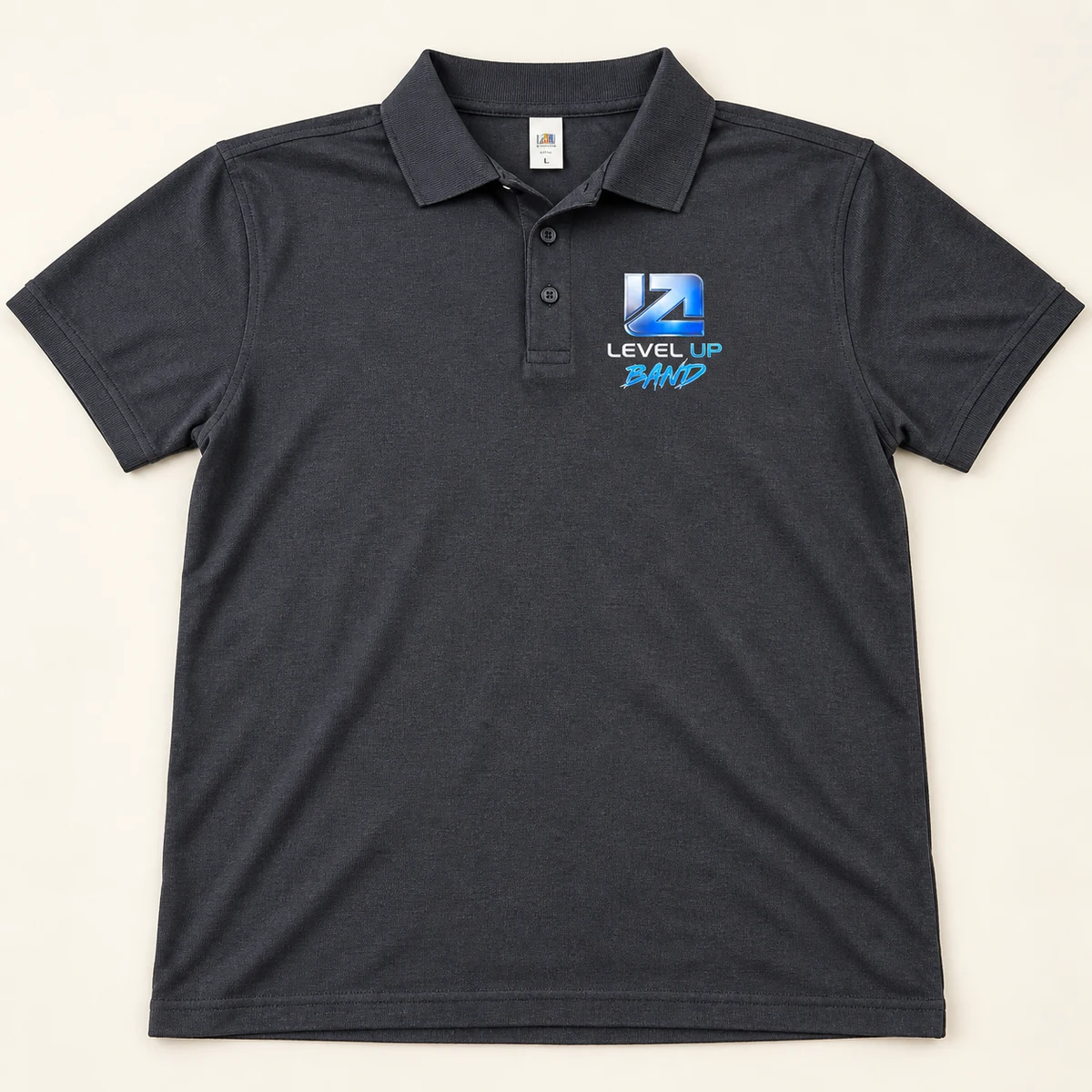 Temno siva polo majica z majhnim modro-srebrnim logotipom glasbene skupine na prsih